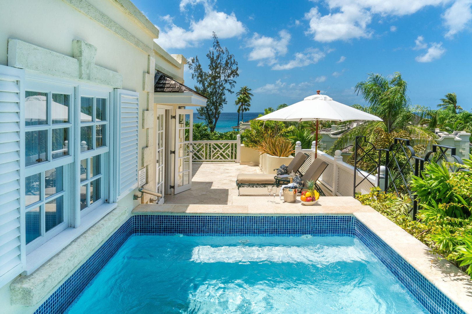 A private pool and sun loungers on a terrace outside a room at Coral Reef Club hotel, Barbados