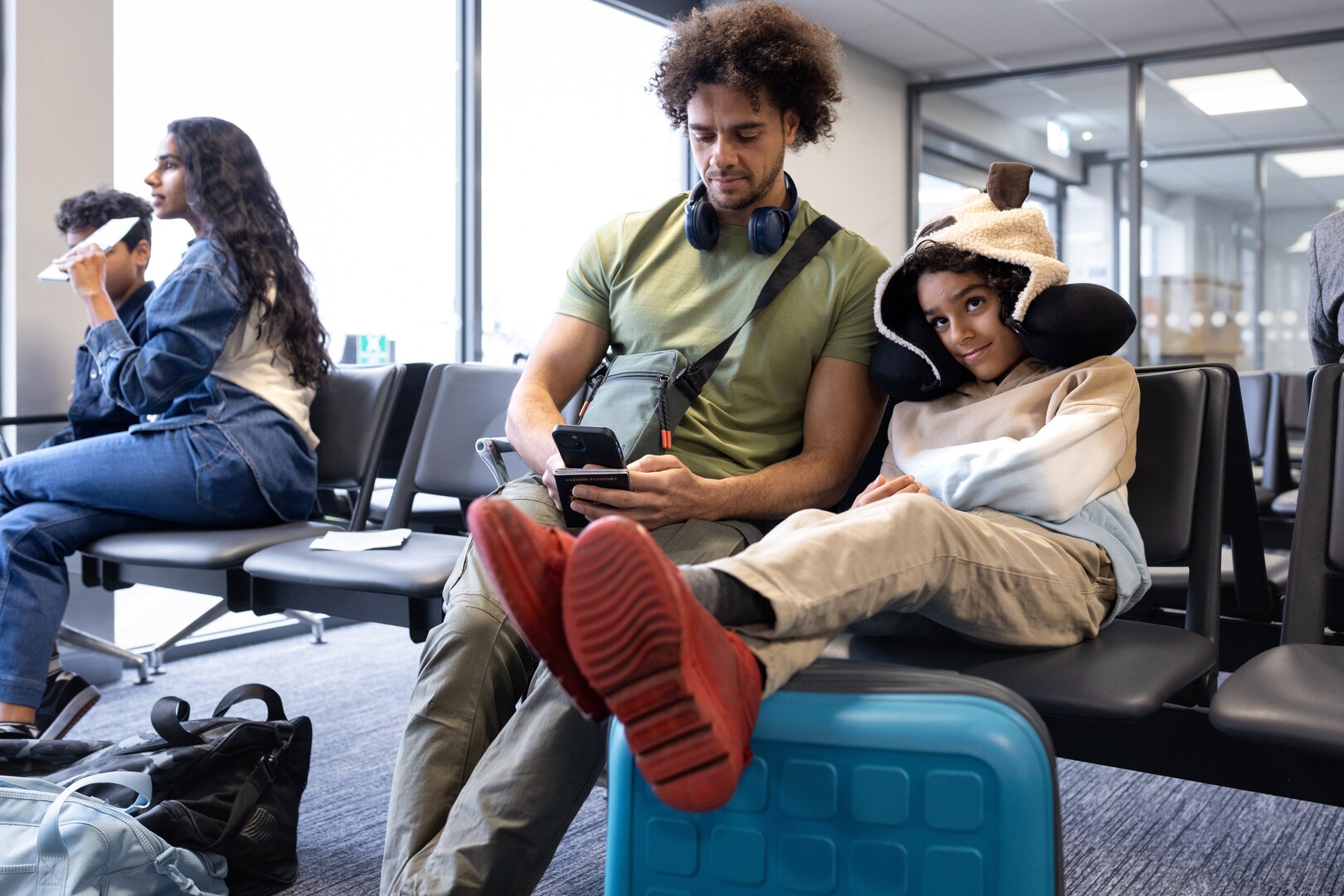 A father and son wait for a flight in an airport departure area