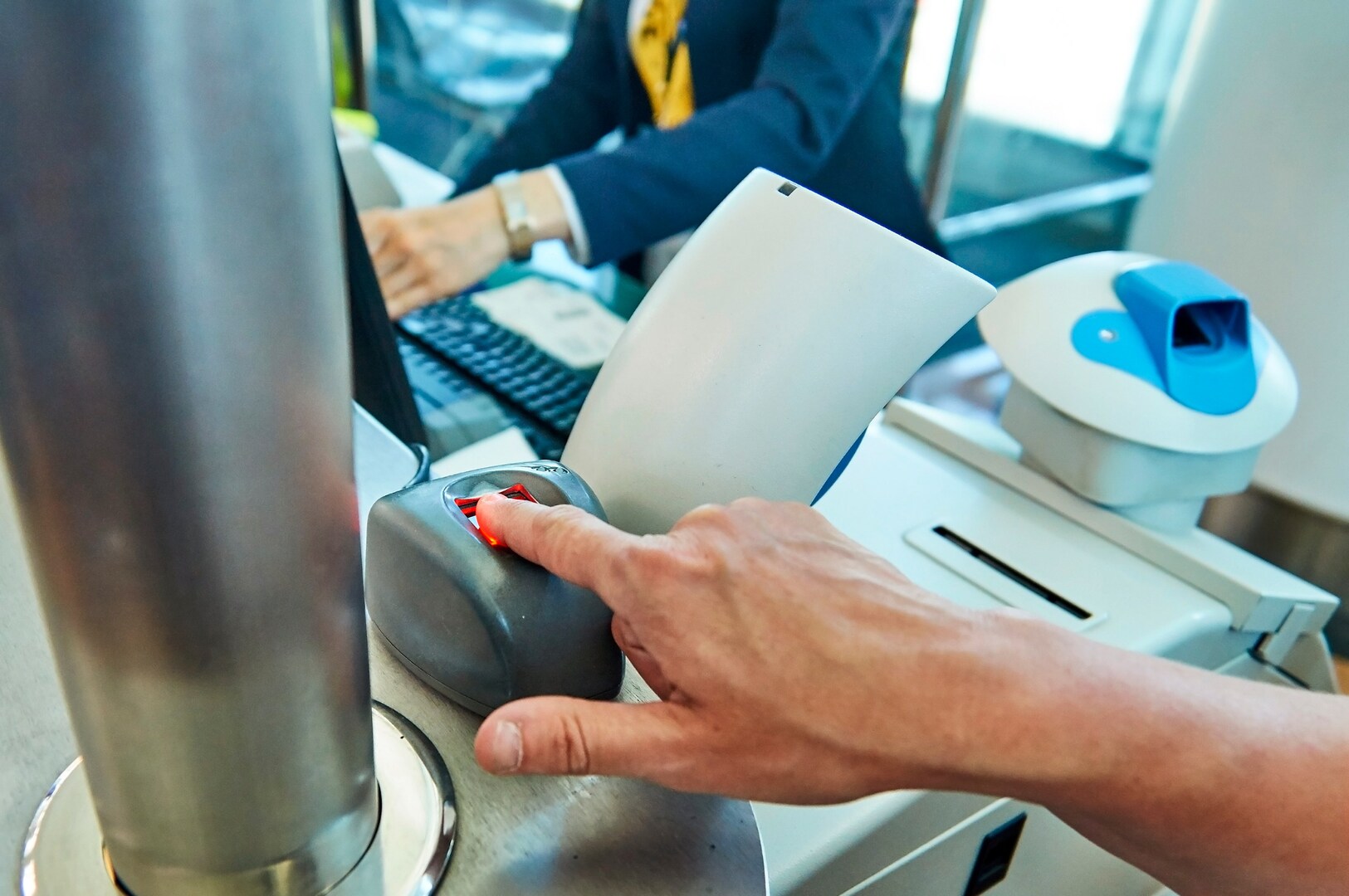A passenger undergoing fingerprinting at an airport for the EES