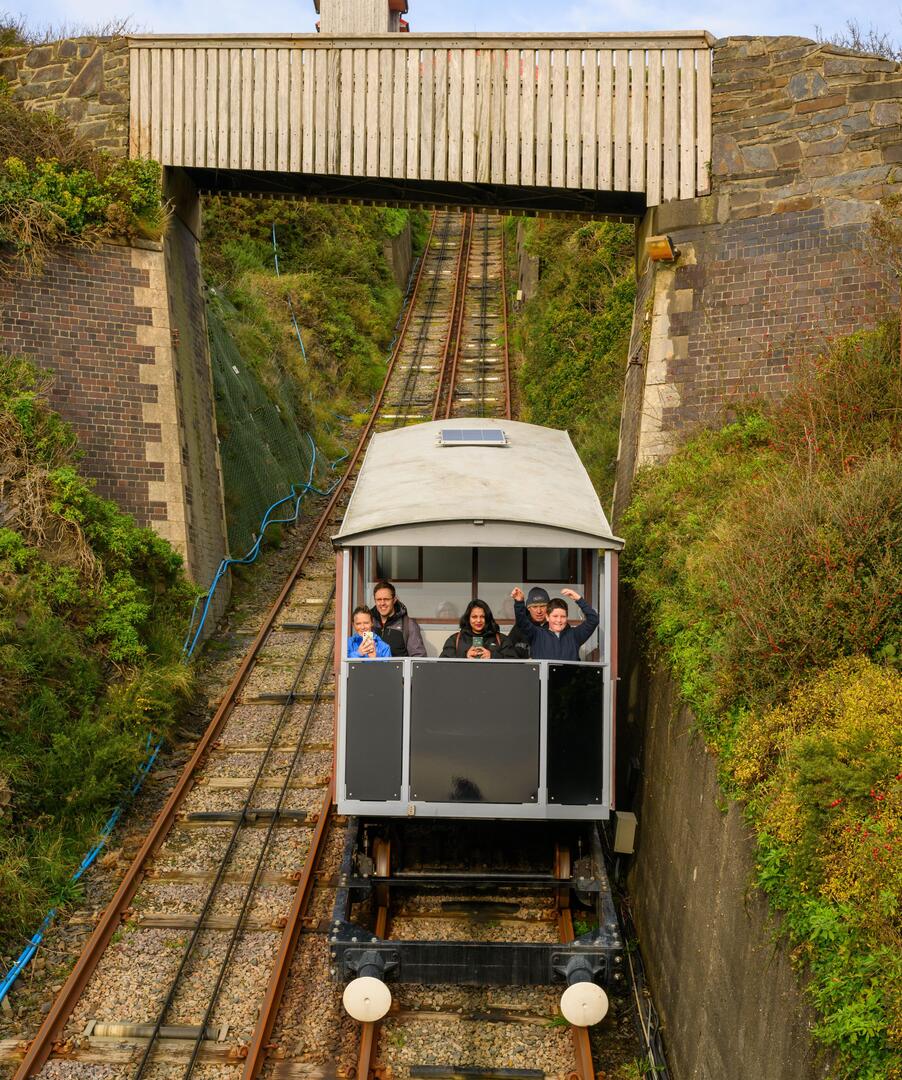 A family rides in a railway carriage on the Aberystwyth Cliff Railway in North Wales.