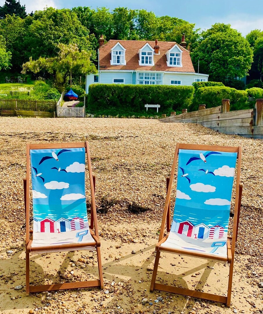 Two beach chairs facing a beach house.
