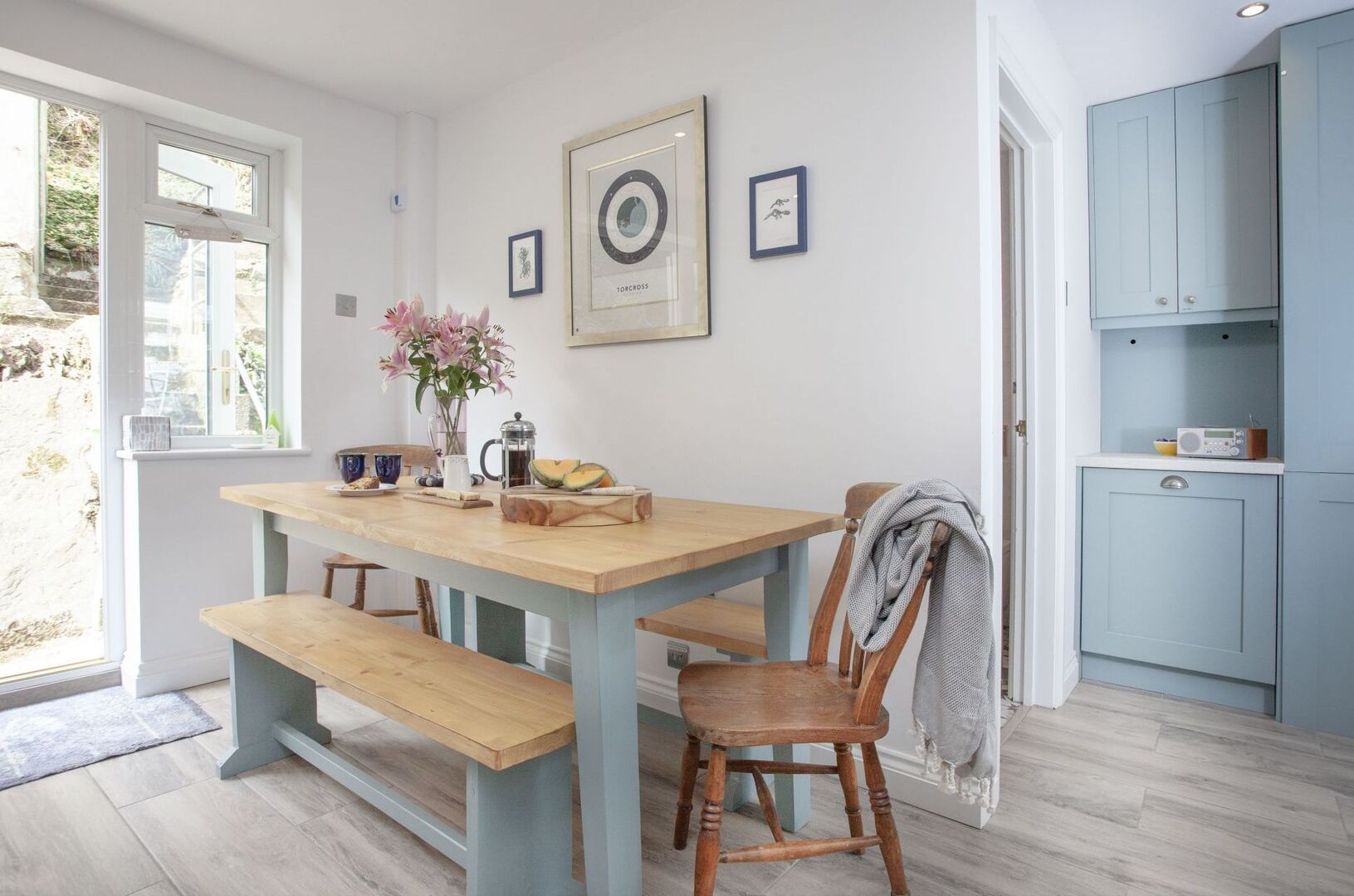 Dining area with light blue cabinets and a wooden table.