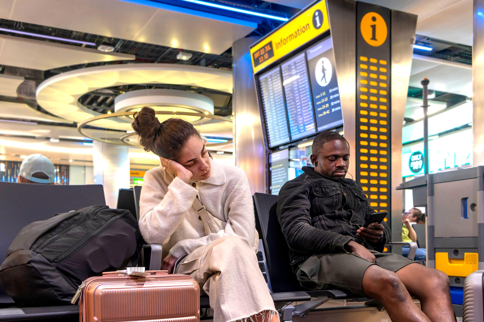 Travellers wait in an airport departure area